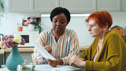Two women looking at a piece of paper