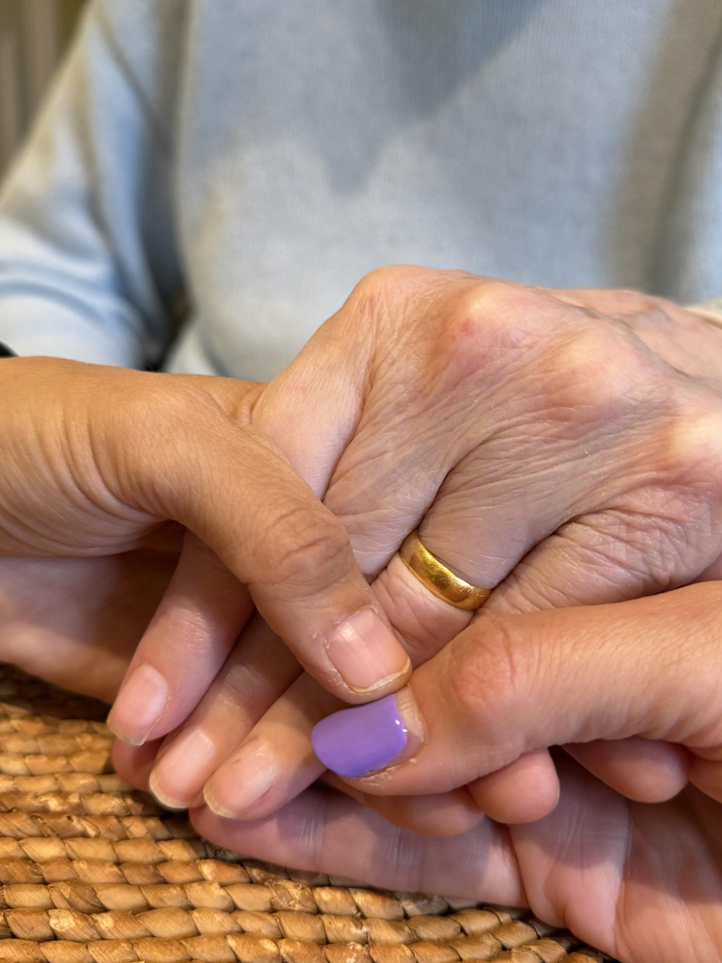 Close up of Alexandra holding her mum's hand