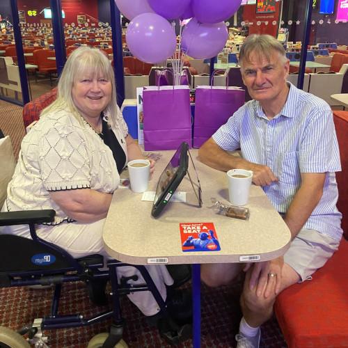 Two people stroke support purple balloons