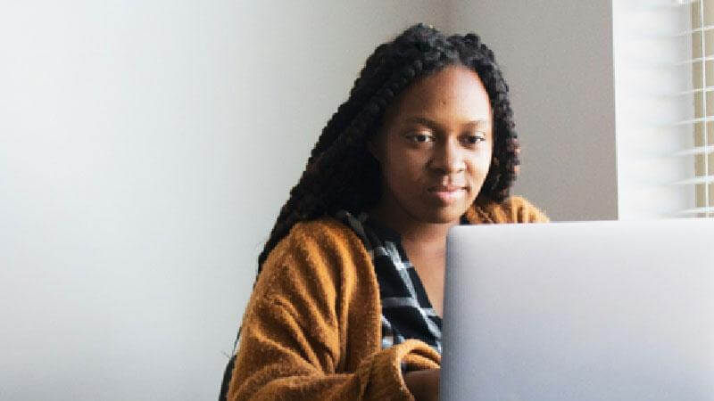 Person sitting at desk on a laptop