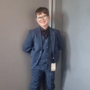 Jacob in a suit, smiling at the camera