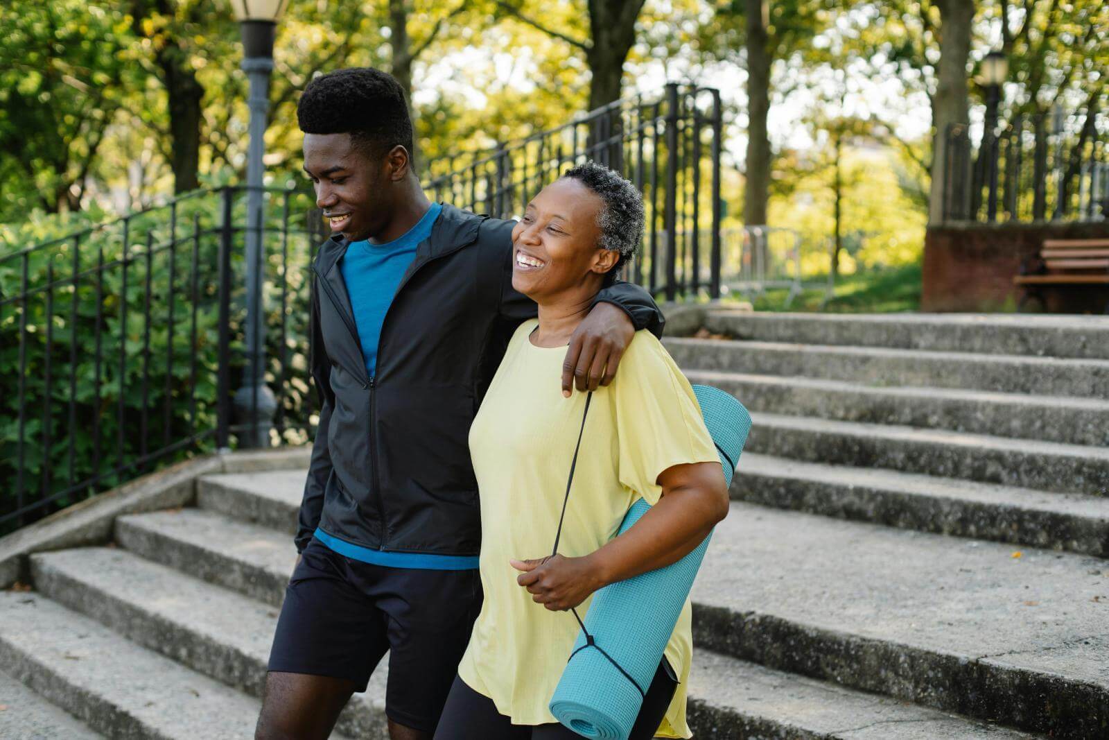 Man and woman in active wear carrying a gym mat