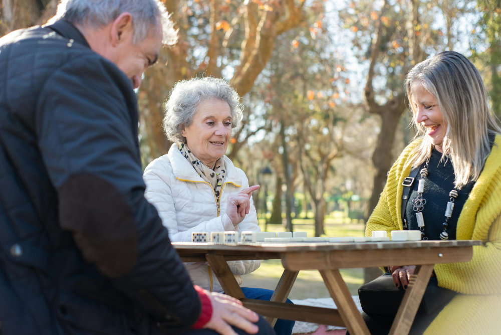 three people sitting at a park table