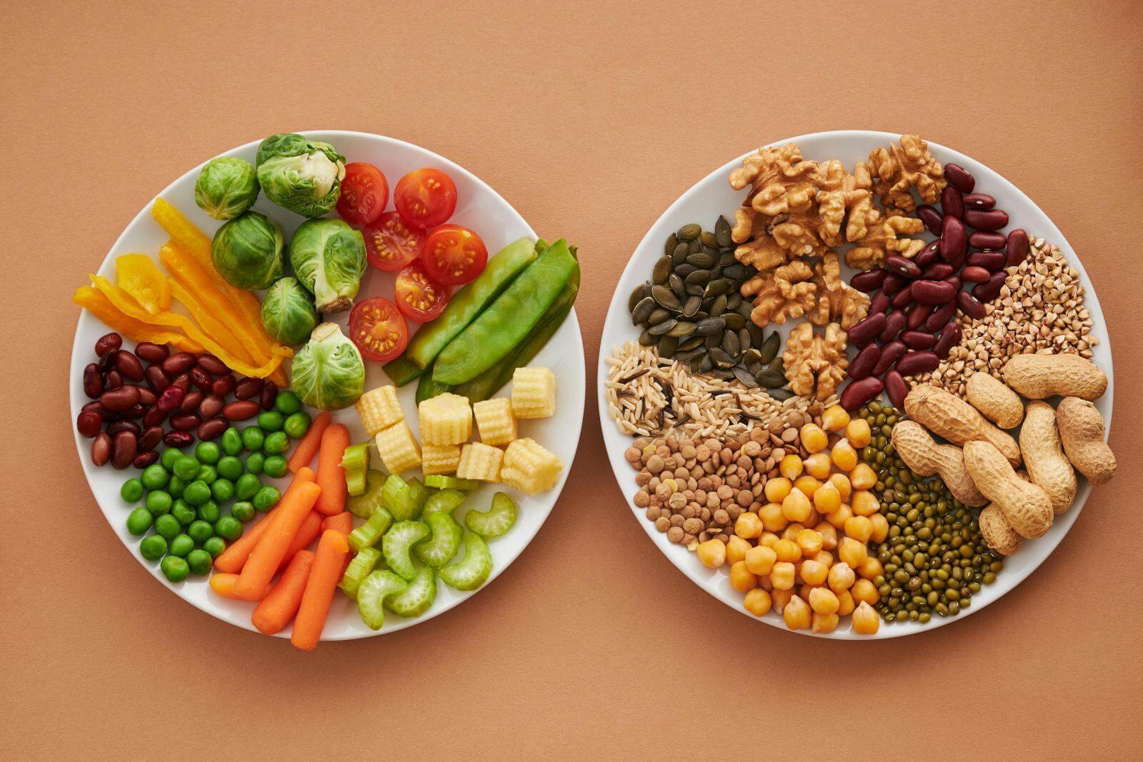 Two plates of healthy and colourful foods, such as pulses and veg