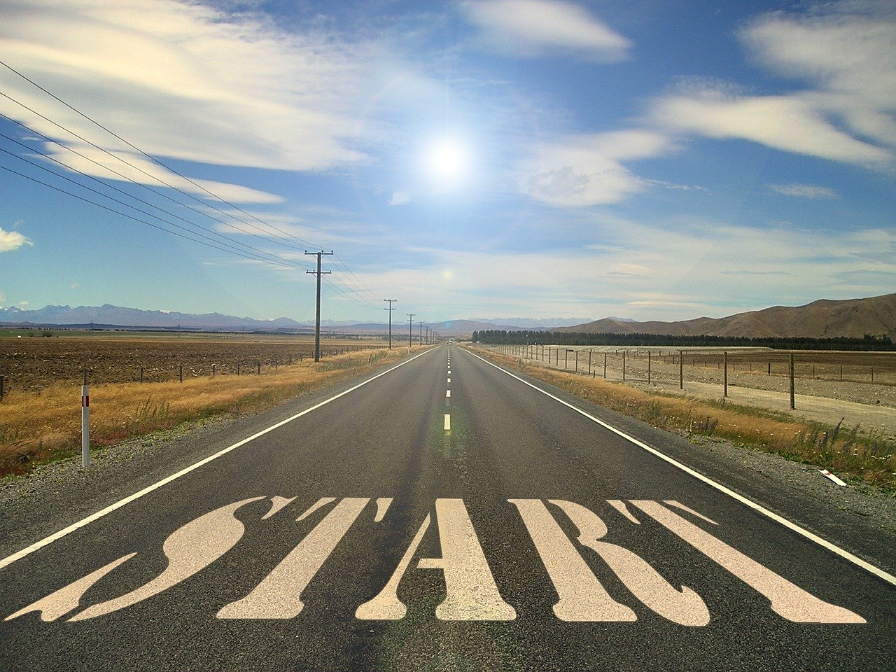A photo of a long road, goes into the distance, on the road, written in large white text, says 'start'