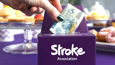 Stroke Association money box with a five pound note on the top 