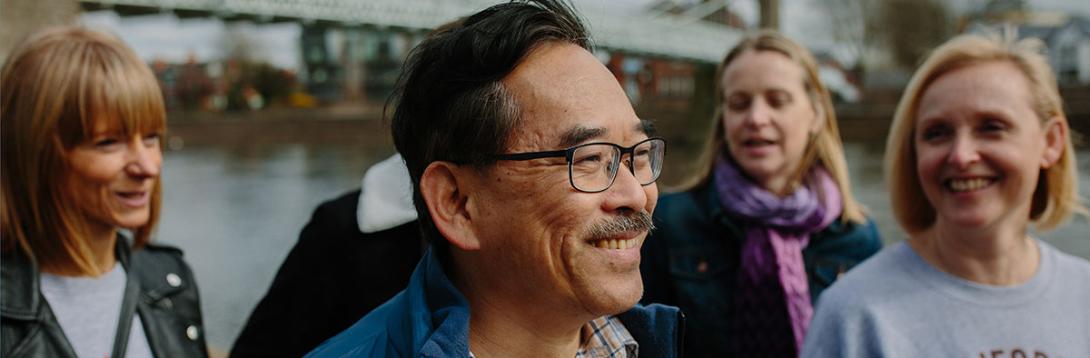 A man smiling among a group of people that are also smiling.