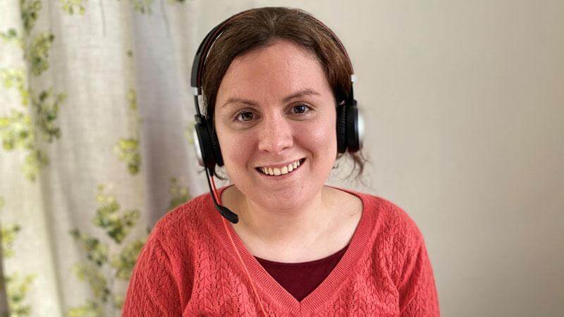 Vicky smiling at camera wearing headset