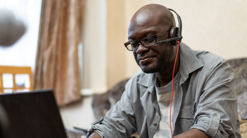 An image of stroke survivor, Roger, working with a headset.