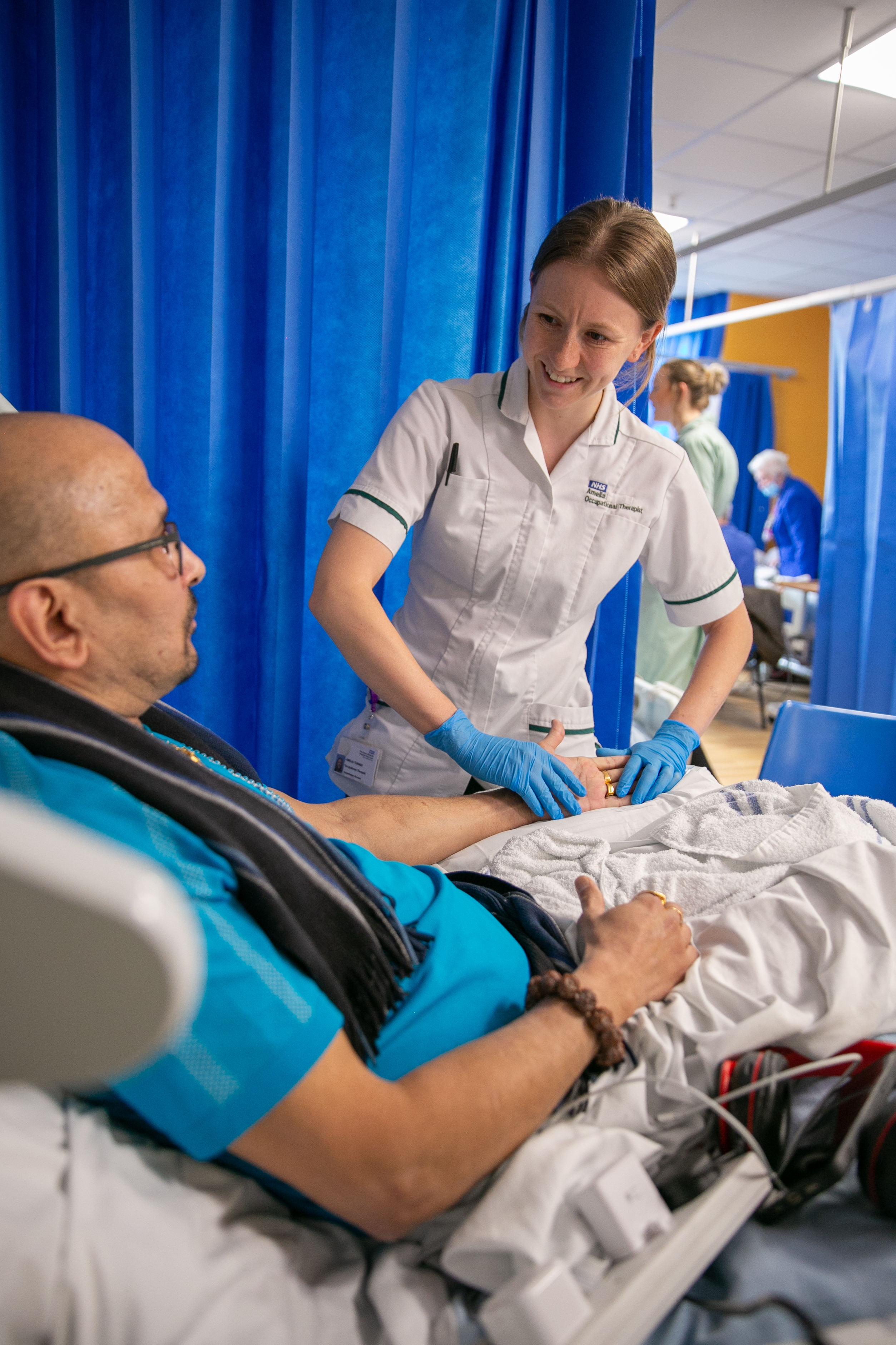 An occupational therapist is practicing physiotherapy on a patient in a hospital