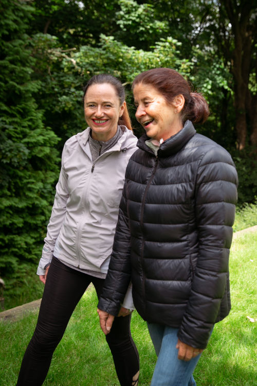 two women laughing and walking