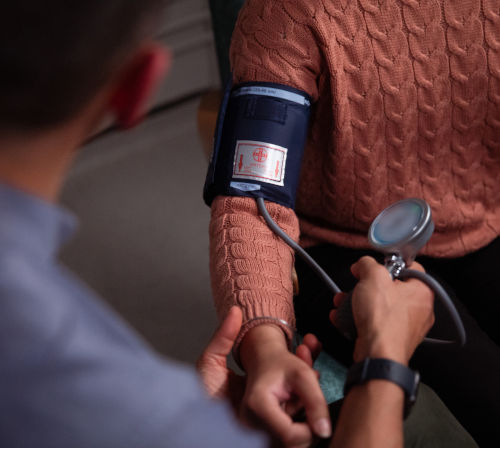 A health professional taking someone's blood pressure.