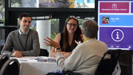 A table of three people talking at UKSA 2018 Manchester