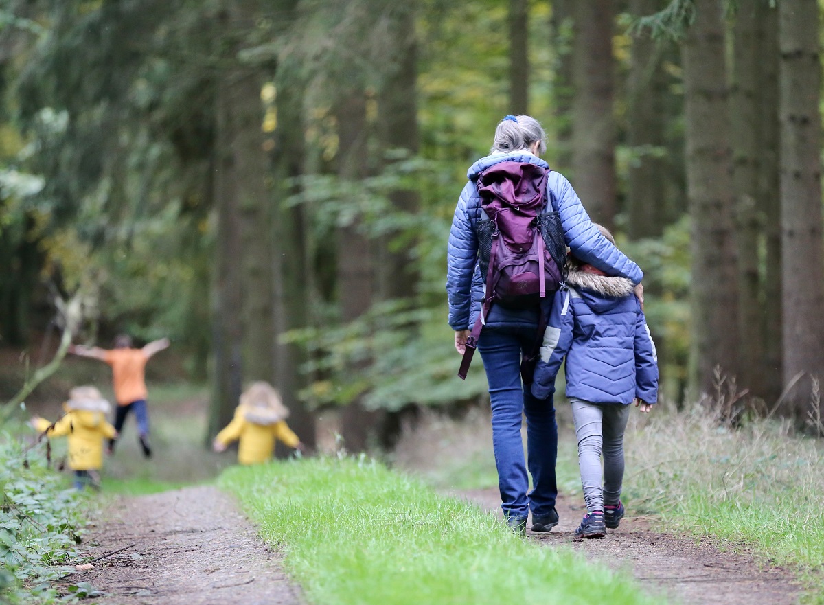 Image of woman walking with child in the forest