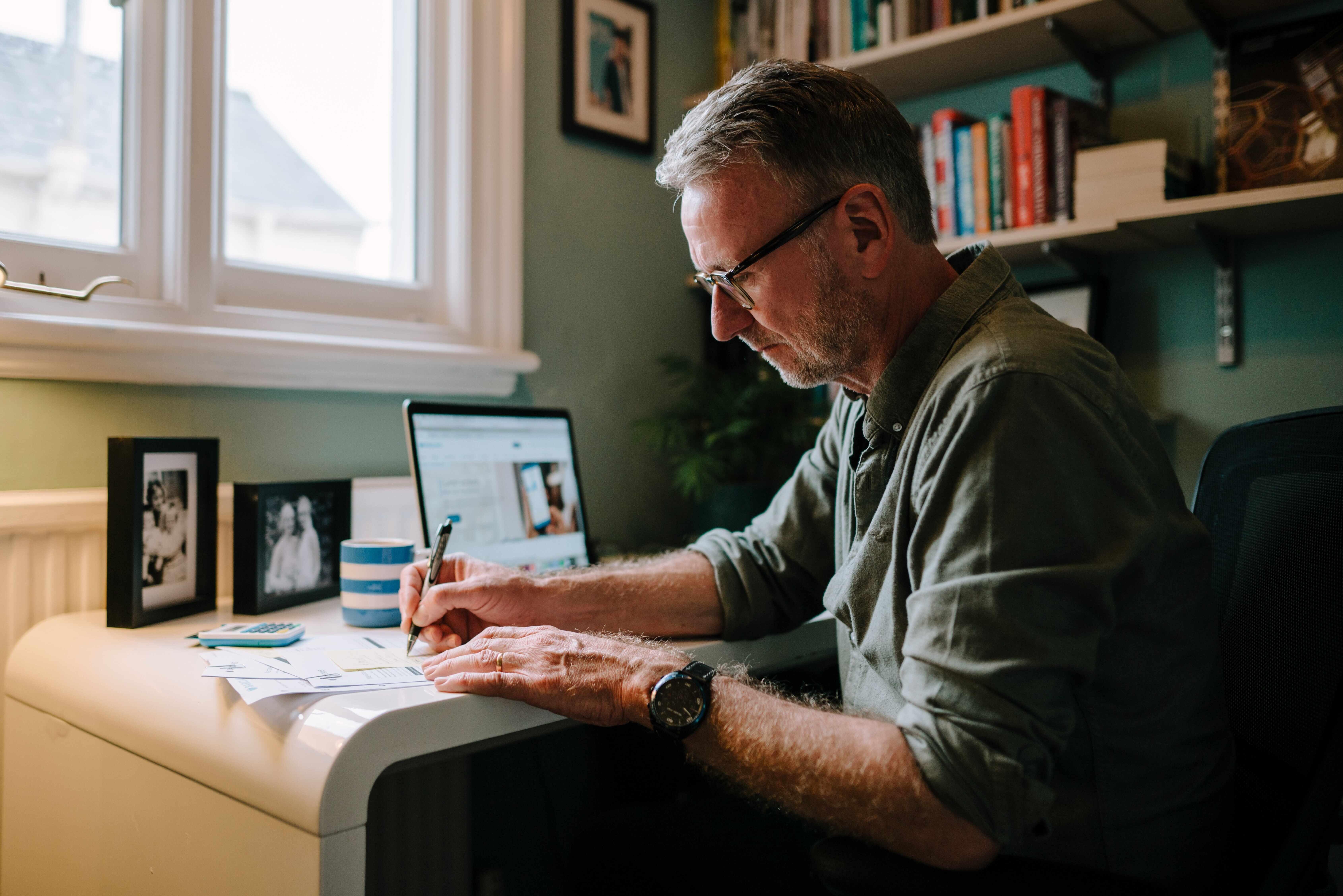 Man writing at desk in home office