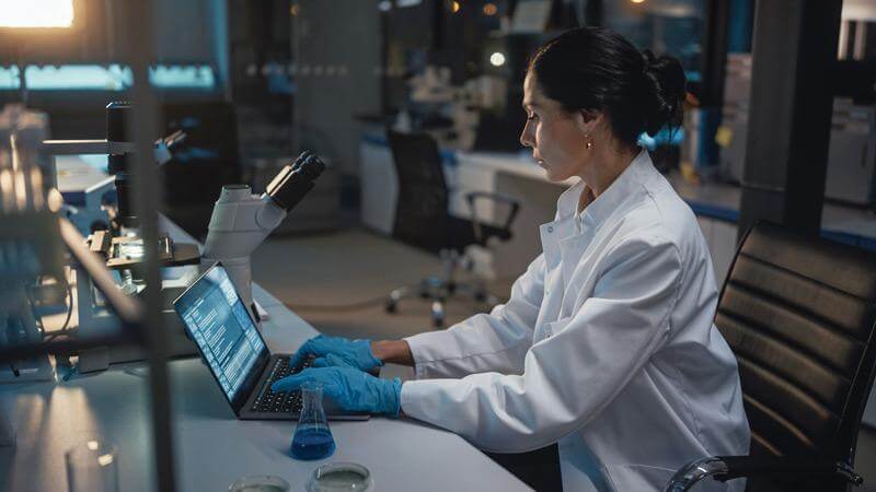 Stock photo of a scientist in a lab on her computer