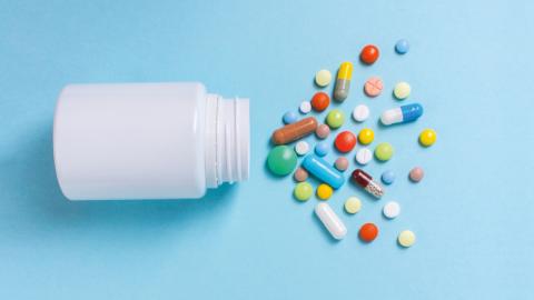 Tablet bottle on its side with tablets spilling out