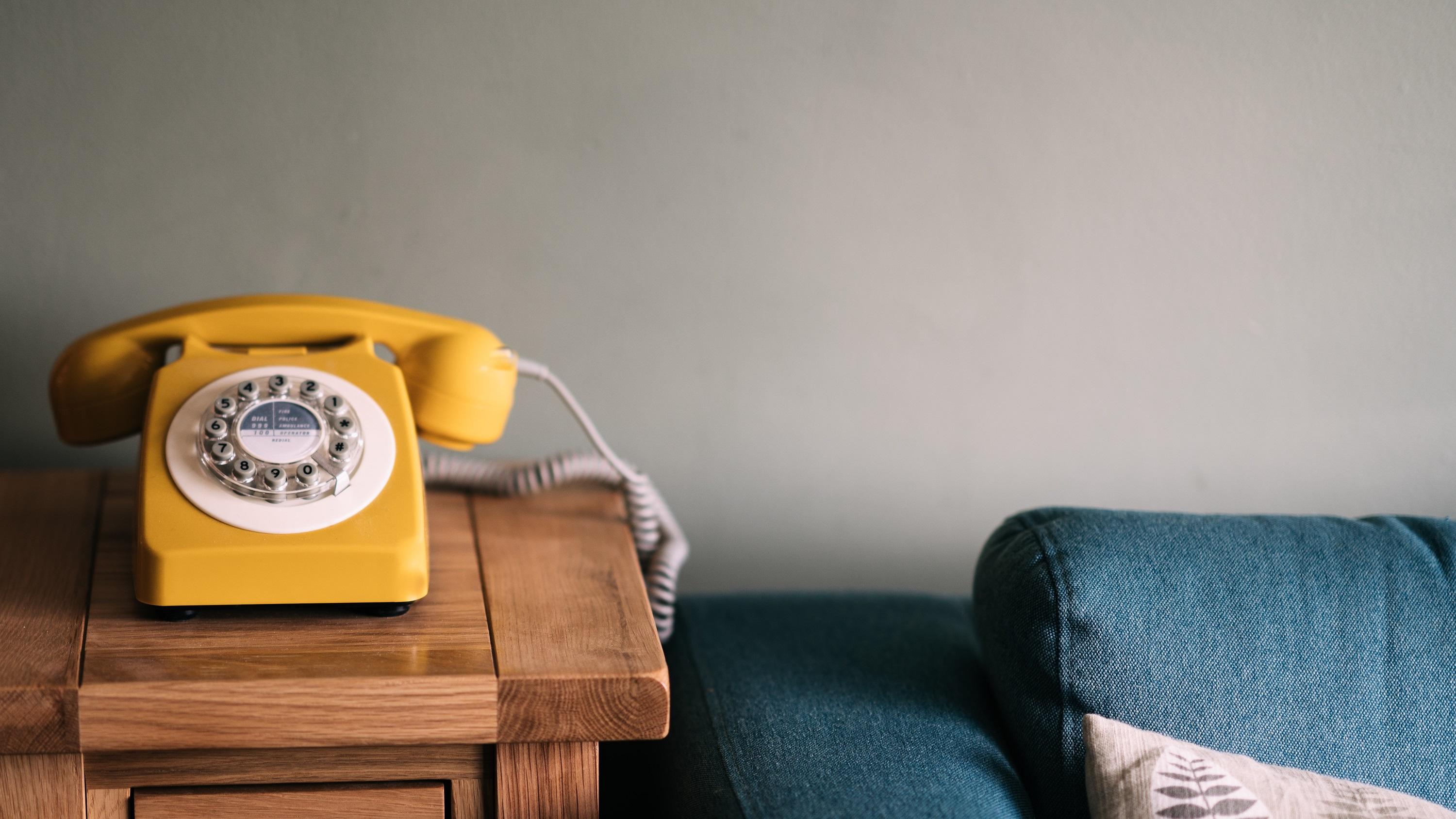 Image of yellow telephone next to a sofa