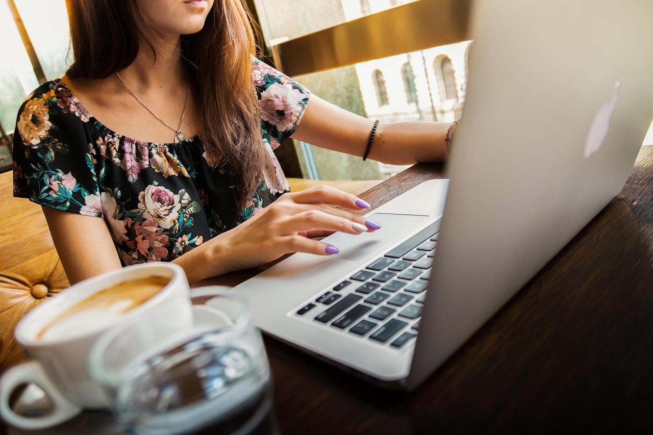 Woman on a laptop with a coffee on her table