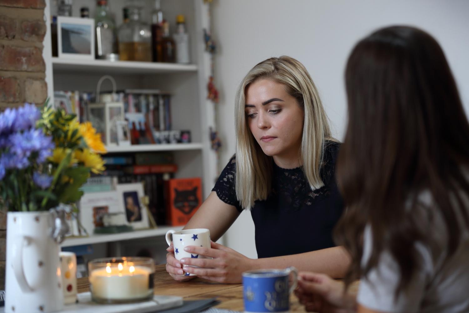 woman looking upset with a cup of tea