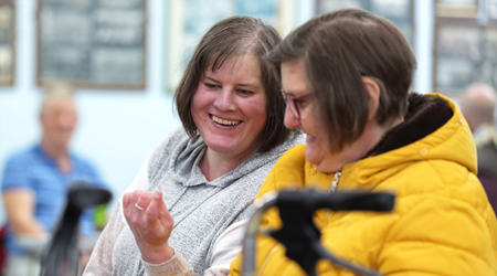 Two people chatting at a group meeting.