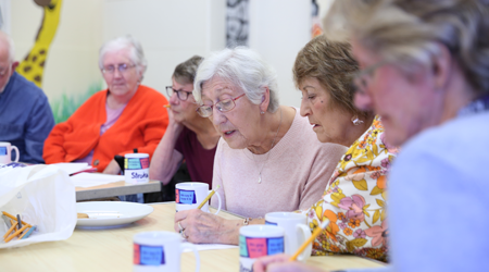 Photo of a group of people doing a seated activity at a stroke group meeting
