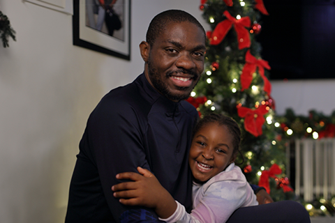 Alex and his daughter smiling at the camera