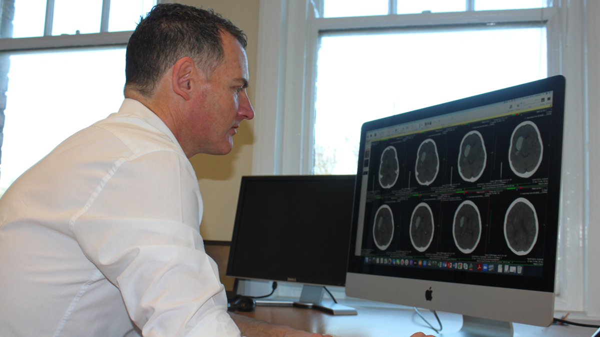 Doctor looking at a computer screen of brain scans